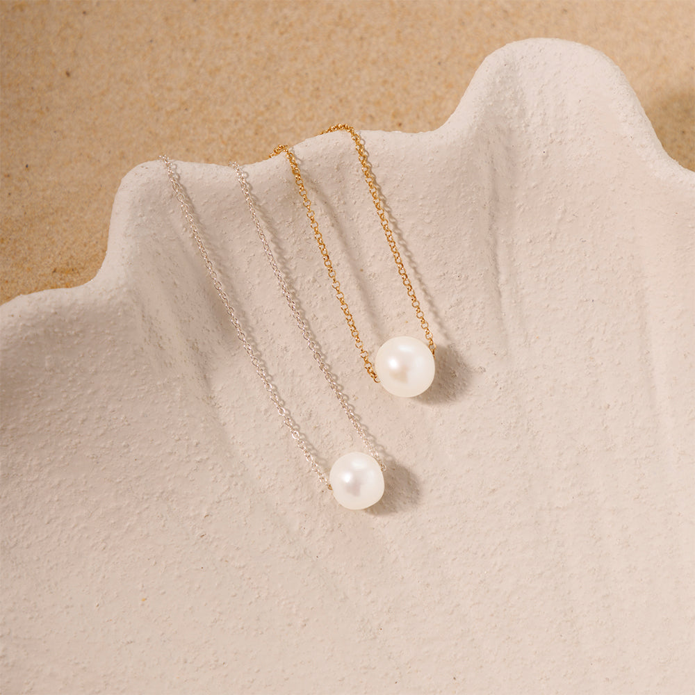 Two necklaces showcased side by side, one in silver plated and the other in gold plated, each featuring a single pearl pendant as the centerpiece.