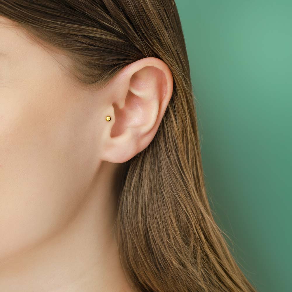 Model wearing 9ct gold 3mm ball piercing in 6mm length.