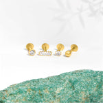 Marketing image of 9c gold piercings, 4 different styles, placed on next to each other agains white background. 