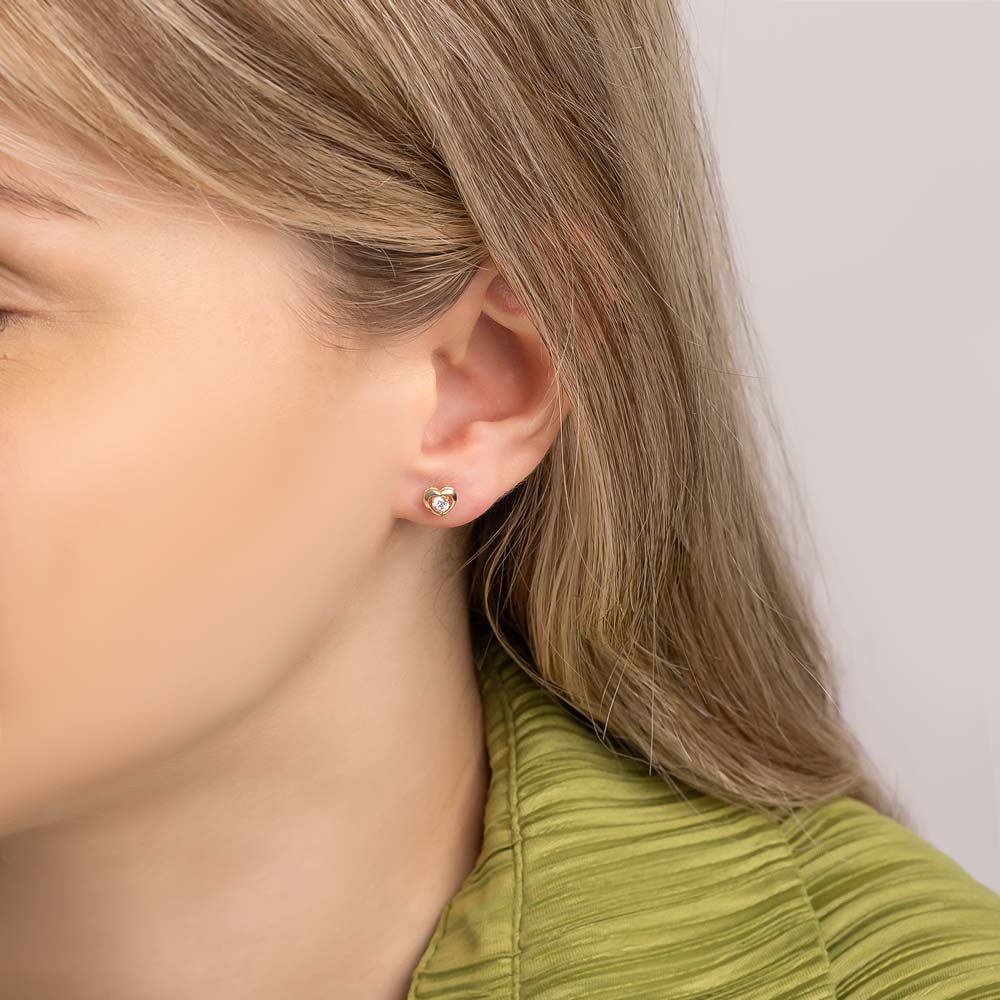 Heart studs with simulated stone worn by a woman.