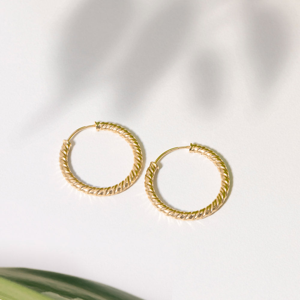 Classic Gold Hoop Earrings showcased on a pristine white surface