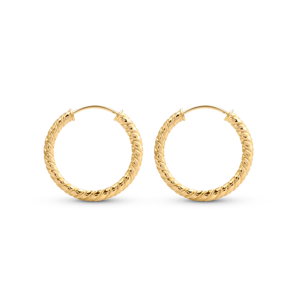 Gold hoop earrings with rope pattern placed against a white background