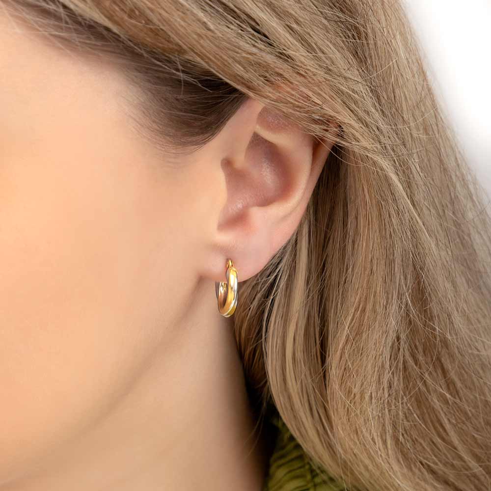 Close up picture of a woman wearing 2 tone 10 mm gold twisted hoop earrings