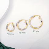 Three pairs of 2 tone gold twisted hoops earrings placed on a white surface