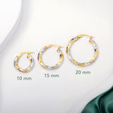 Three pairs of 2 tone gold twisted hoops earrings placed on a white surface