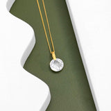 An image showing one 9ct gold Round crystal pendant placed on a green and white background.