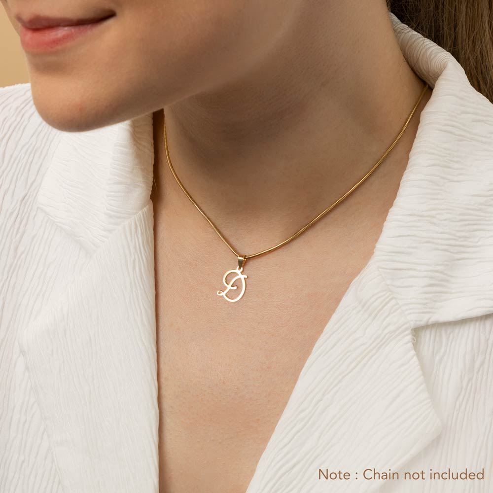 A woman wearing a gold necklace with an alphabet pendant in the shape of the letter 'D'. The text in the corner notes, "Note: Chain not included.