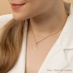 A woman wearing a gold necklace with an alphabet pendant in the shape of the letter 'G'. The text in the corner notes, "Note: Chain not included.