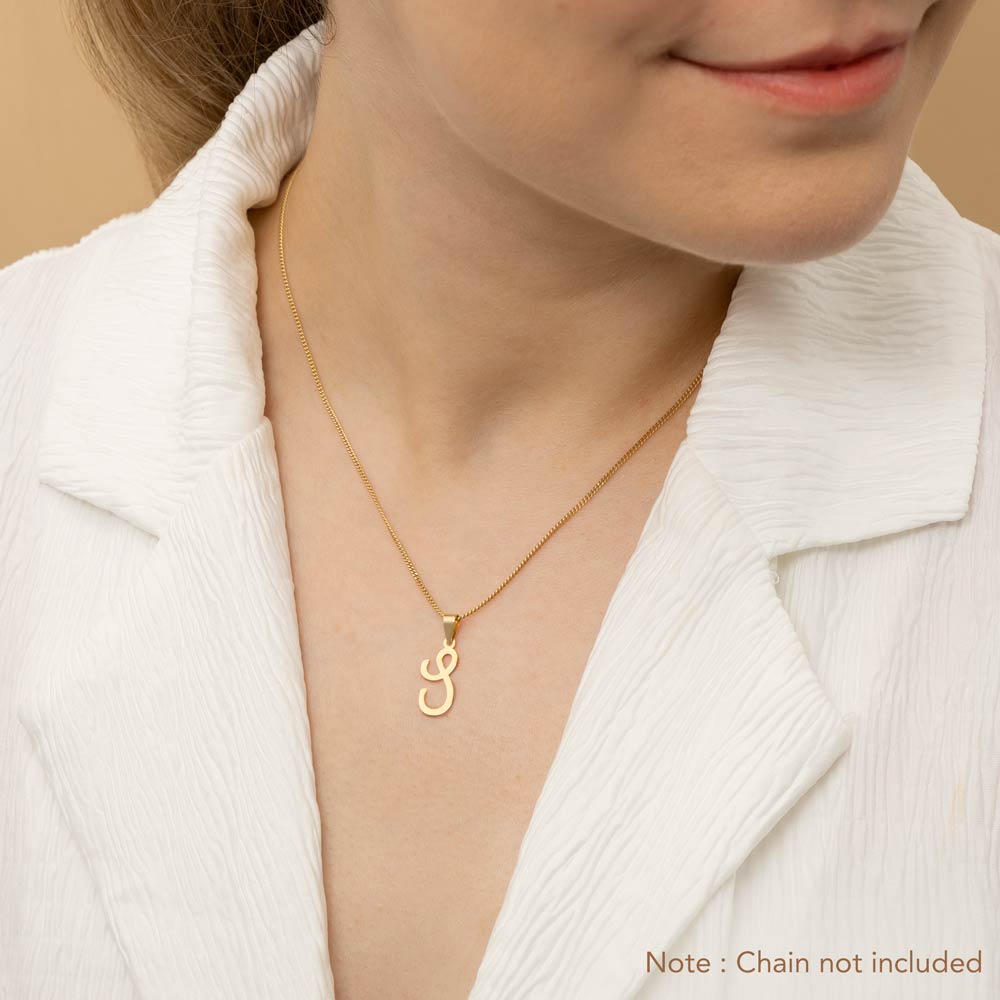 A woman wearing a gold necklace with an alphabet pendant in the shape of the letter 'S'. The text in the corner notes, "Note: Chain not included.