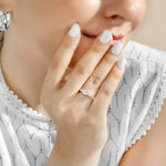 Woman wearing silver engagement ring with CZ stone in 6mm against white blouse. 