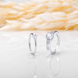 An image showing two silver engagement rings placed on a white and beige background.