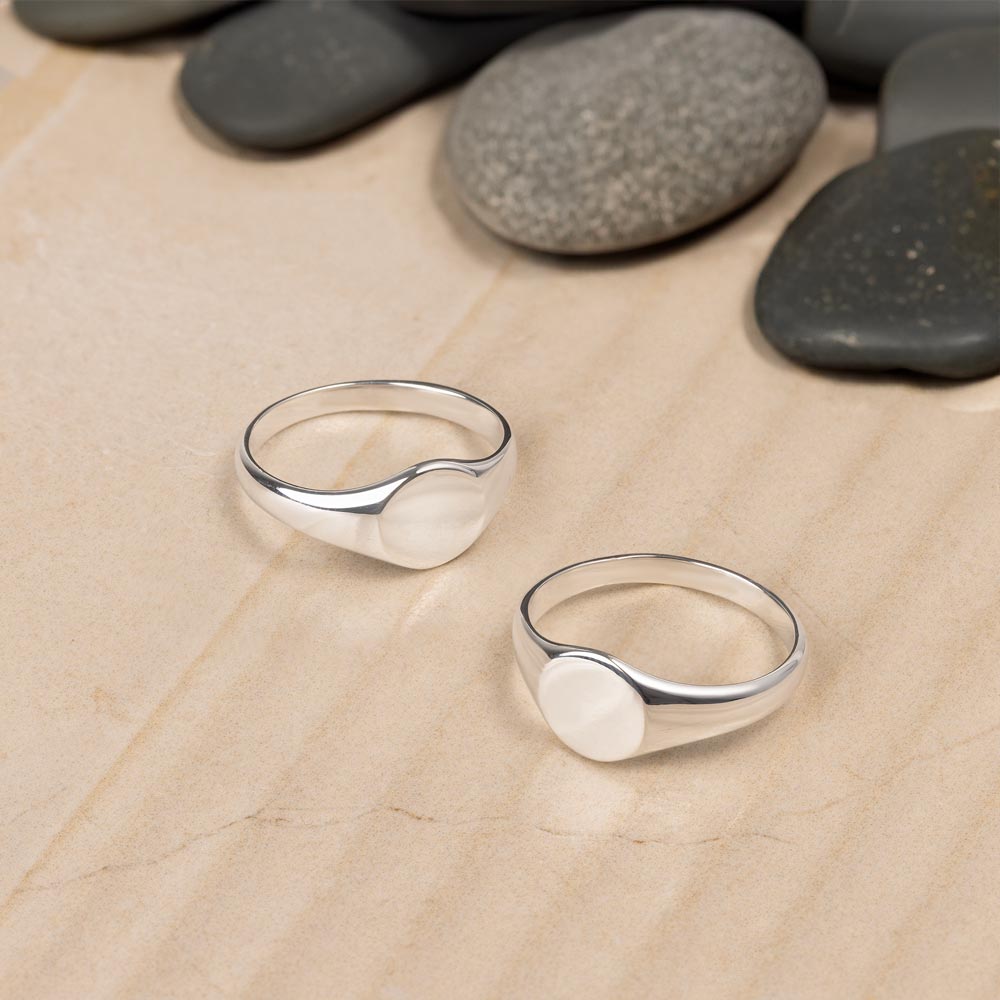 Two flat signet rings placed on beige tile. 