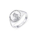 A broad silver ring with St Christopher emblem on it placed on a white surface