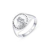 A broad silver ring with St Christopher emblem on it placed on a white surface