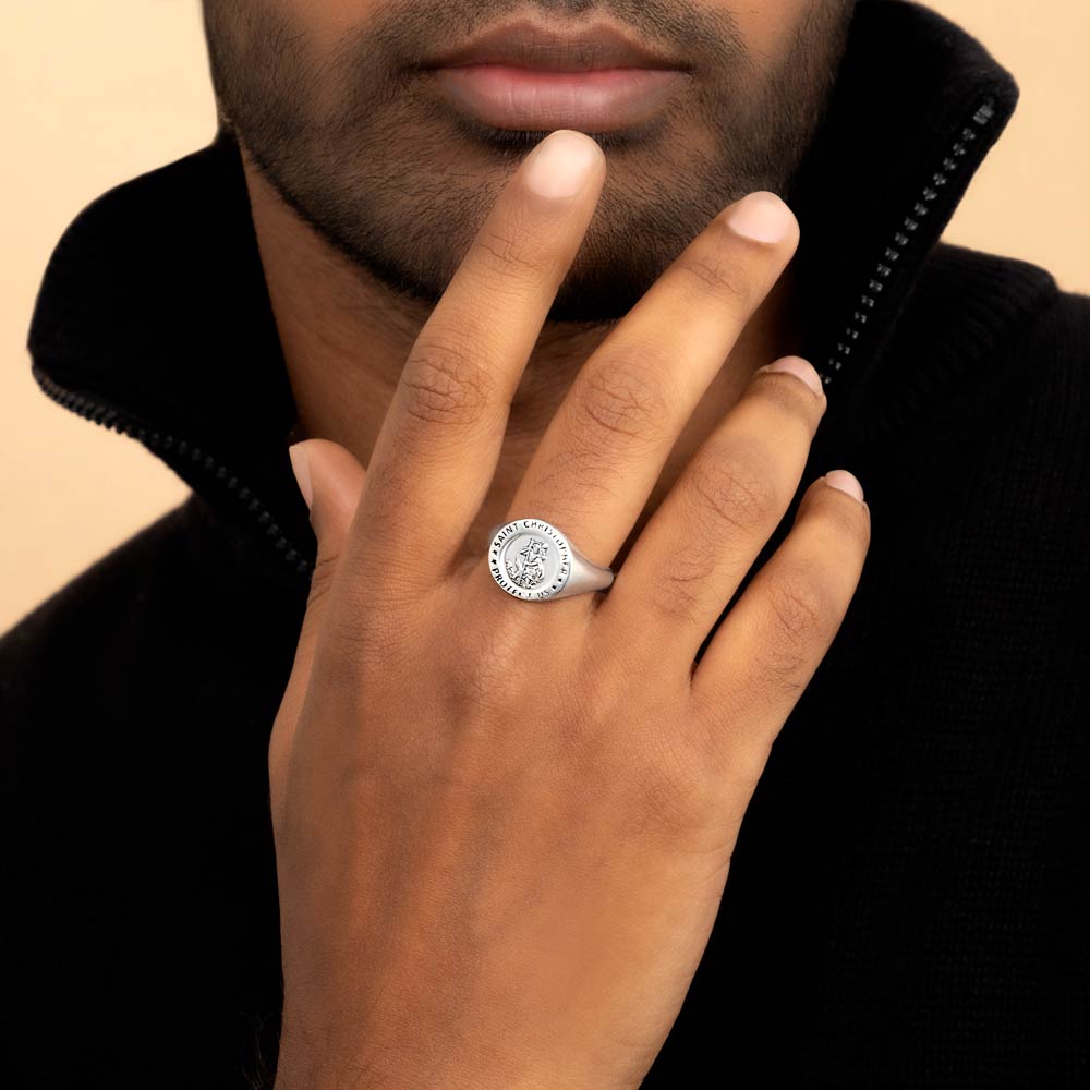 A distinguished gentleman showcasing a St.Christopher signet ring on his finger, embodying luxury