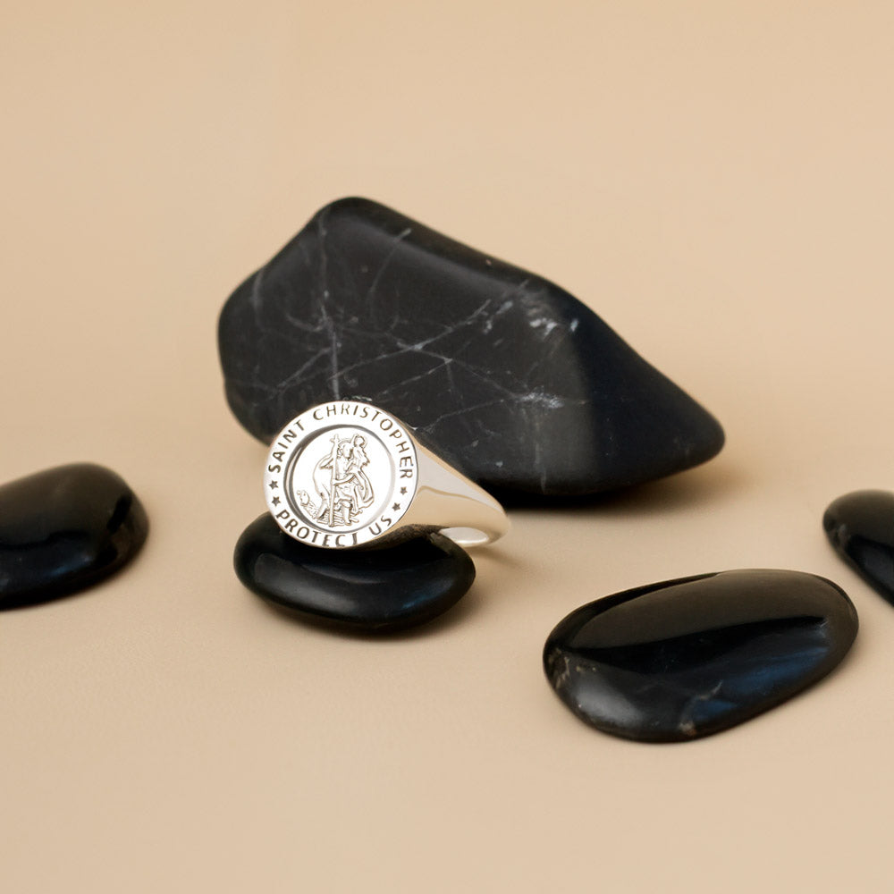 St Christopher signet ring resting on a black stone, a symbol of protection and guidance. 