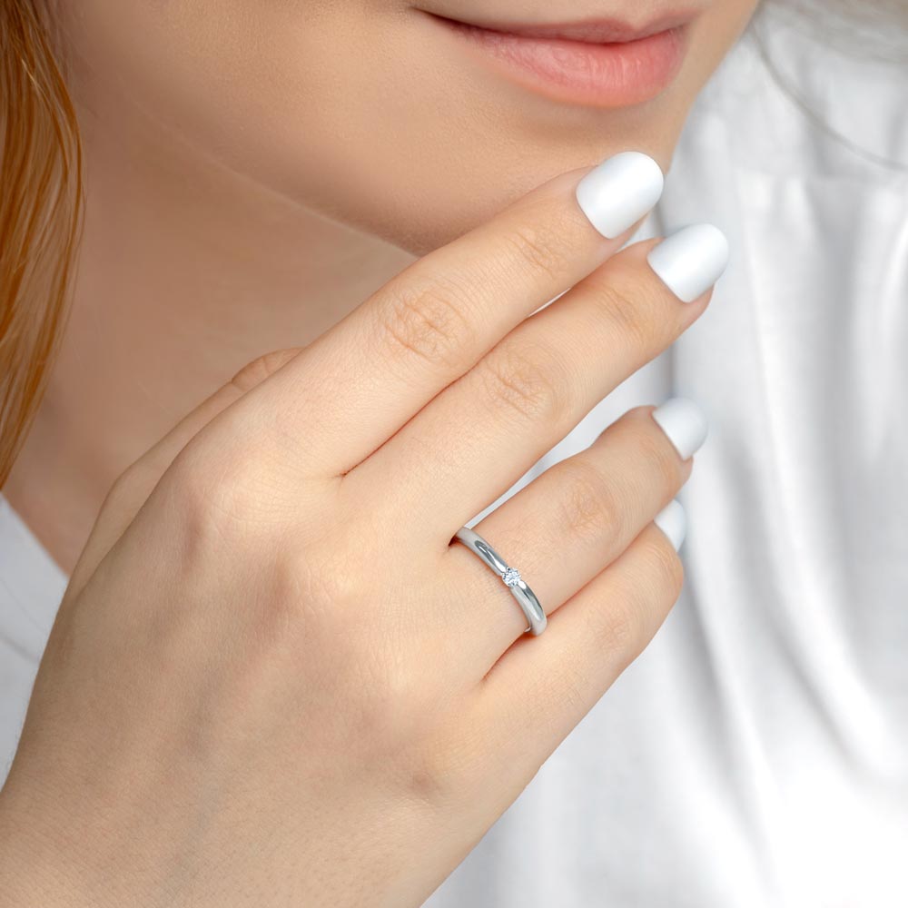 Woman wearing silver solitaire wedding band with CZ stone in 3mm.