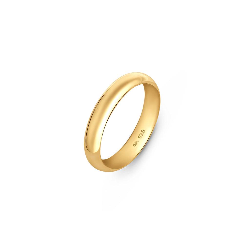 Gold plated wedding band in 4mm thick placed on a white surface.