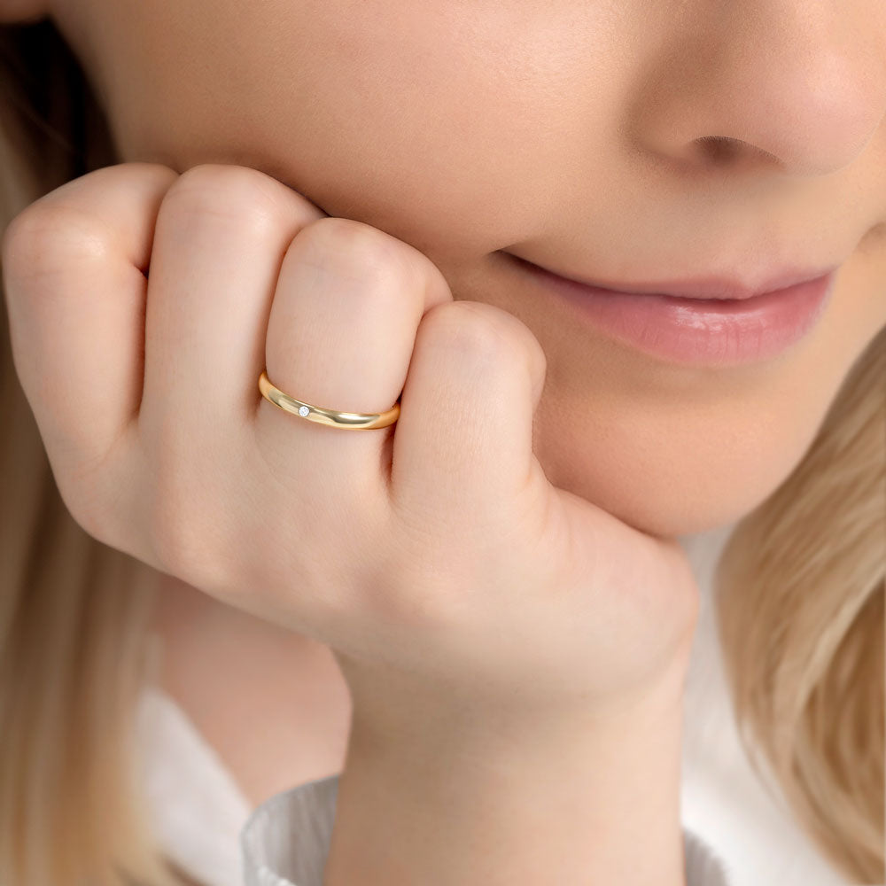 A woman in a white blouse wearing a 9ct gold wedding band with 1.3 mm cubic zirconia stone