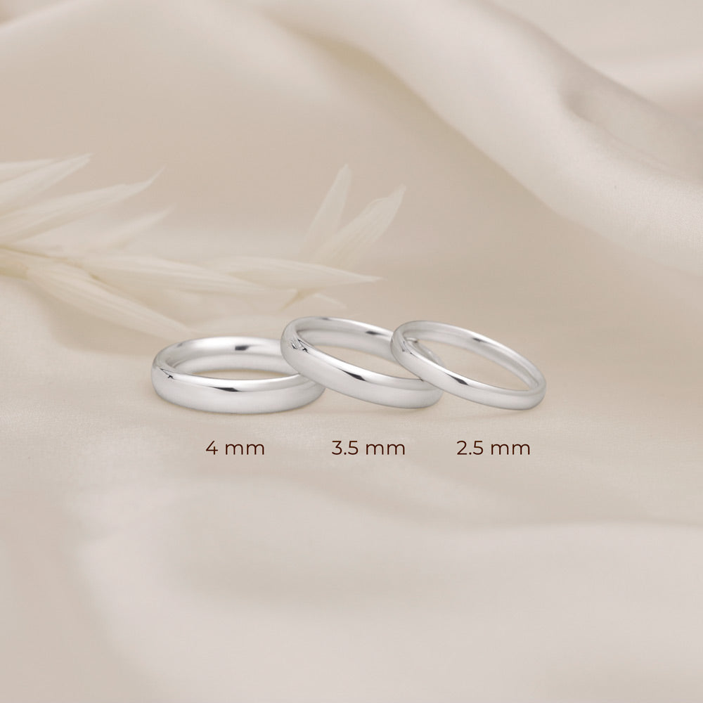 Three silver rings of different thickness 2.5mm 3.5mm 4mm placed next to each other to show its size difference